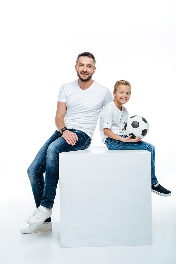 Πατέρας και γιος που κάθεται με μπάλα ποδοσφαίρου  - Φωτογραφία, εικόνα