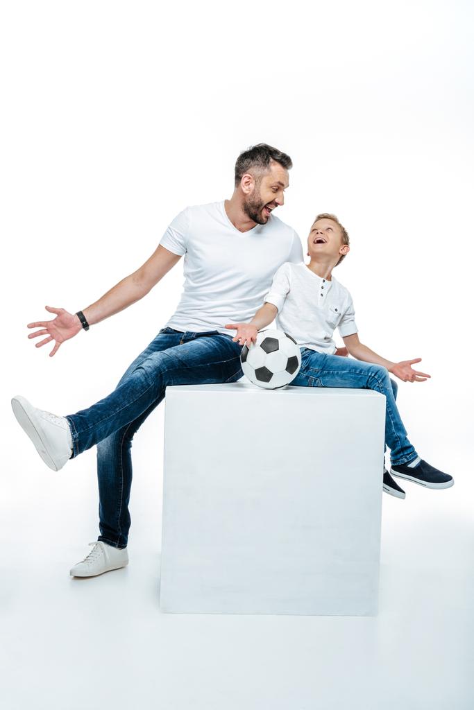 Vader en zoon zitten met voetbal  - Foto, afbeelding