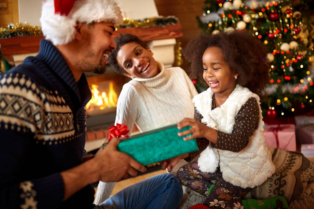 Lachen van afro-Amerikaanse familie uitwisselen van cadeaus voor kerst - Foto, afbeelding