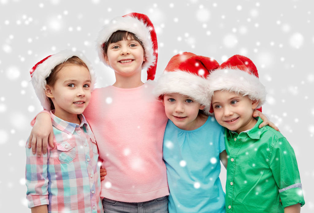 heureux petits enfants dans santa chapeaux câlins
 - Photo, image