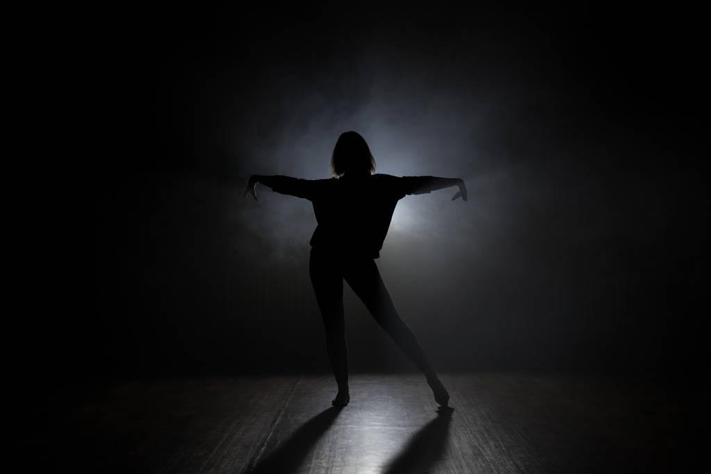 Χορεύτρια σε studio με smooke σε σκούρο φόντο - Φωτογραφία, εικόνα