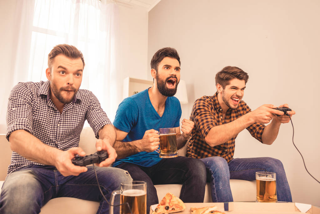 Portrait of excited  cheerful men play video game with beer and  - Photo, Image