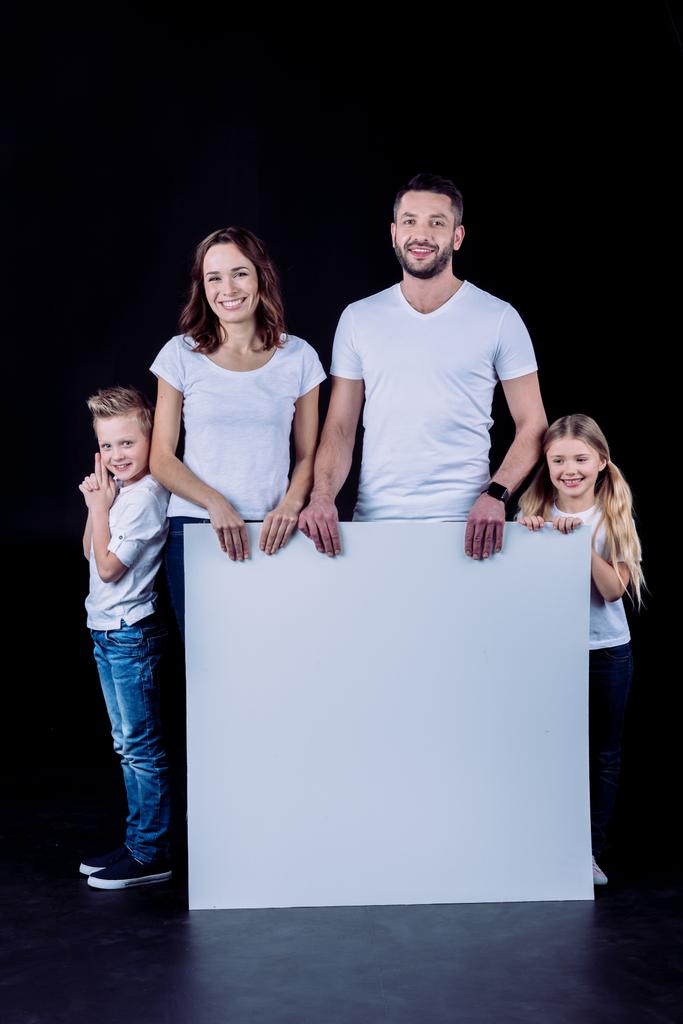 Smiling family holding blank card - Photo, Image