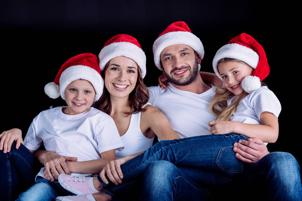 family in Santa hats looking at camera - Photo, Image
