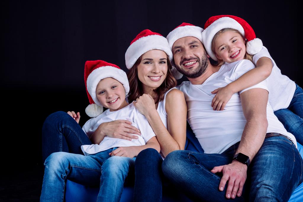 famille dans Santa chapeaux regardant caméra
 - Photo, image