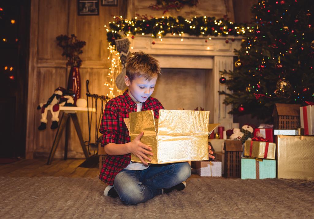 Niño abriendo regalo de Navidad
  - Foto, imagen