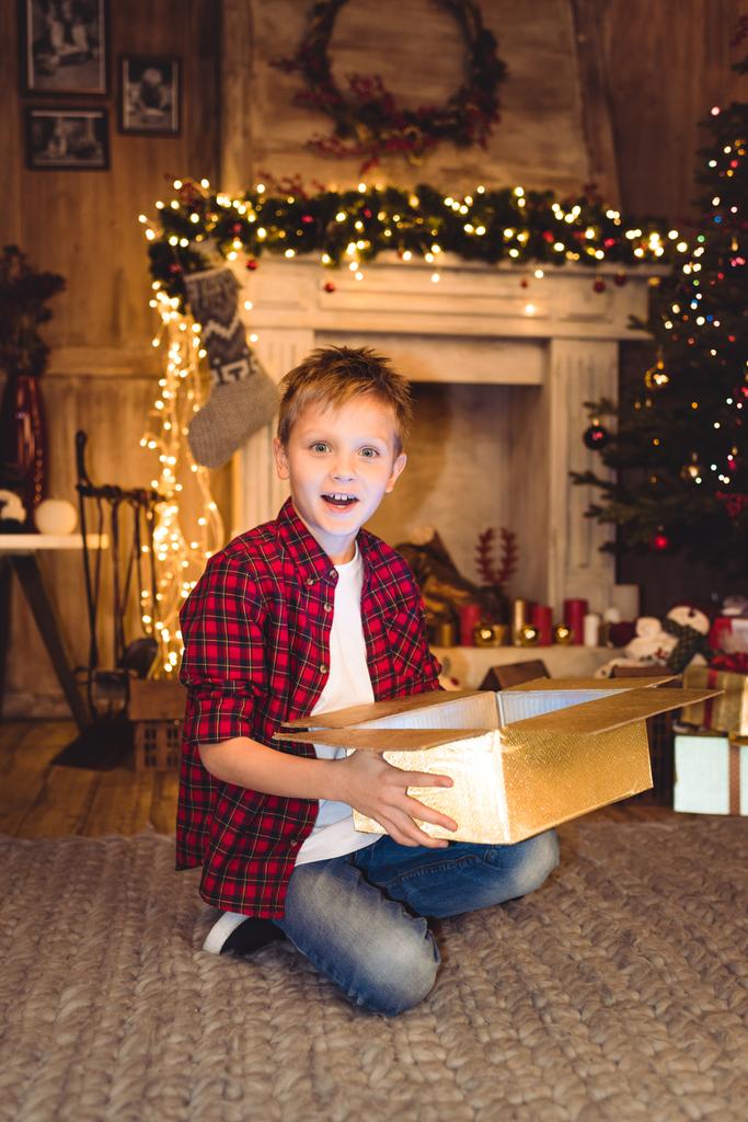 Poika avaamassa joululahjaa
  - Valokuva, kuva