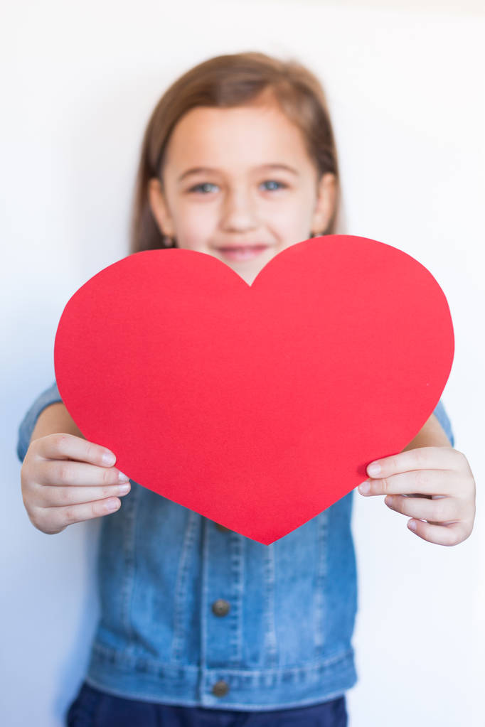 Έξι ετών κορίτσι κρατήστε μεγάλη κόκκινη καρδιά - Φωτογραφία, εικόνα