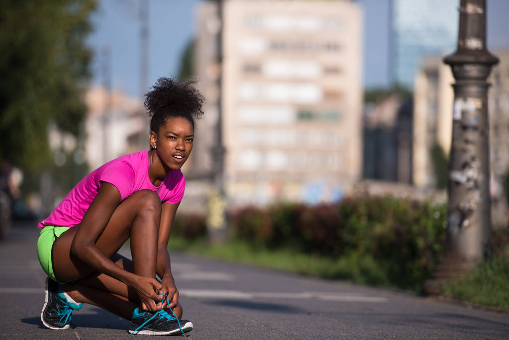 mujer afroamericana corredor apretando zapato encaje
 - Foto, Imagen