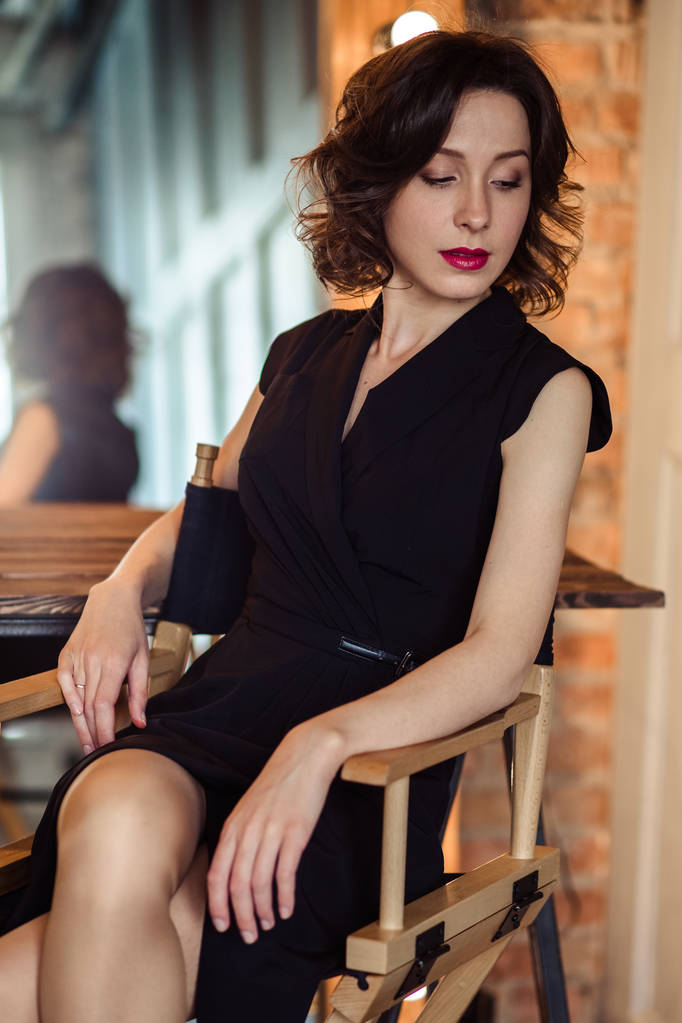 Tendre jeune femme dans une robe noire avec maquillage naturel et coiffure
 - Photo, image