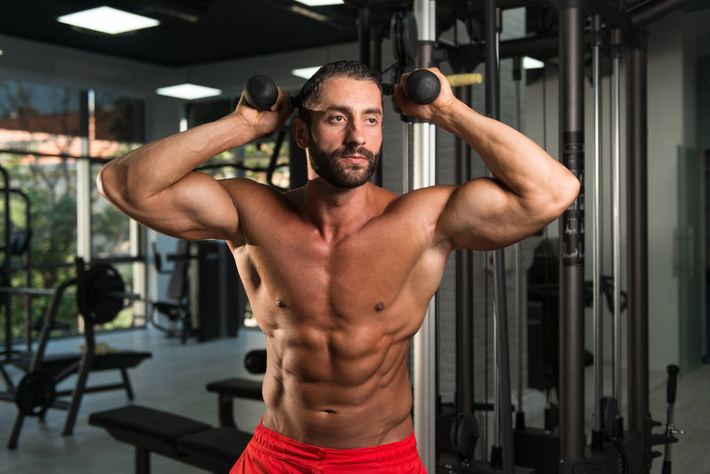 Hiszpanin człowiek wykonywaniu Triceps na siłowni - Zdjęcie, obraz