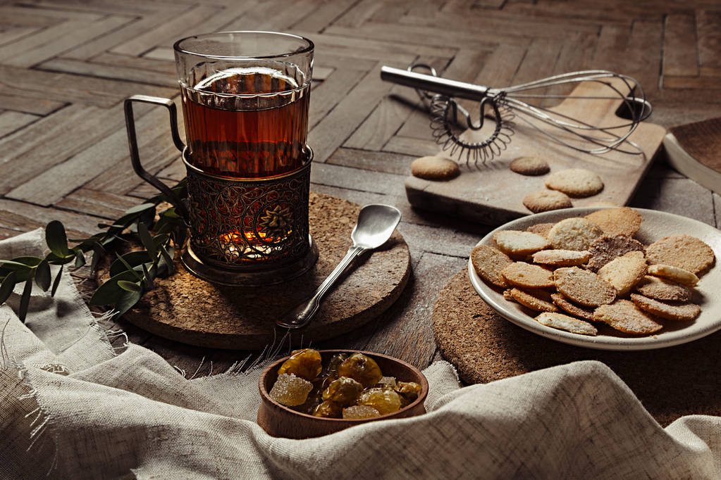 Горячий чай в антикварной держатель чашки с сахаром печенье на старом коричневом фоне дерева
.  - Фото, изображение