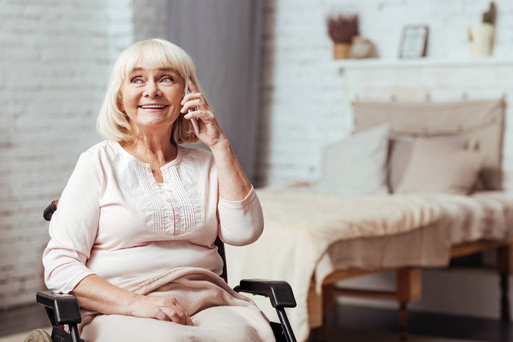 Vidám fogyatékkal élő idősebb nő, beszél szúró telefon - Fotó, kép
