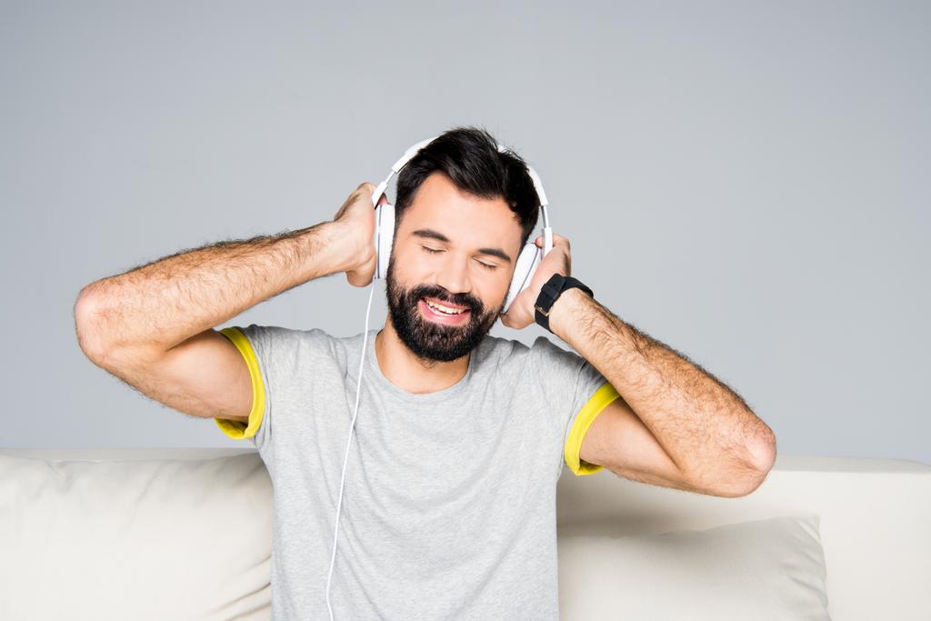 Бородатий чоловік у білих навушниках
  - Фото, зображення