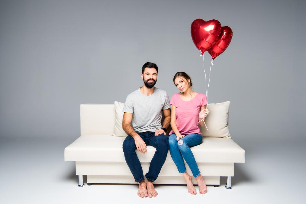 Пара сидящих на диване с красными шариками
 - Фото, изображение