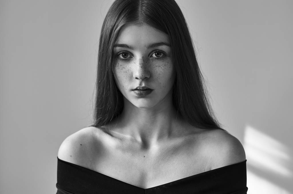 Dramatický černobílý portrét krásné děvčátko s pihy izolovaných na bílém pozadí v záběru studio - Fotografie, Obrázek