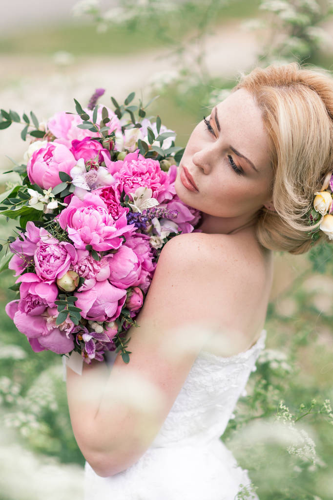 Gyönyörű menyasszony, fehér ruhában, a kertben - Fotó, kép