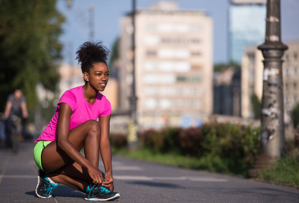 Afrikalı-Amerikalı kadın atlet ayakkabı Dantel sıkma - Fotoğraf, Görsel