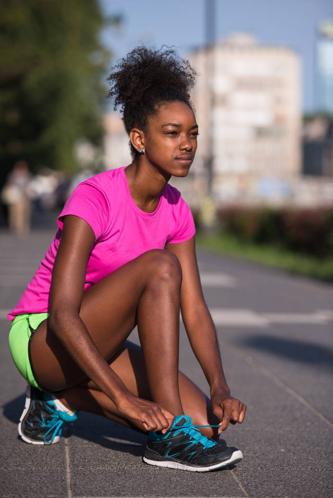 Femme afro-américaine coureur resserrement chaussure dentelle
 - Photo, image