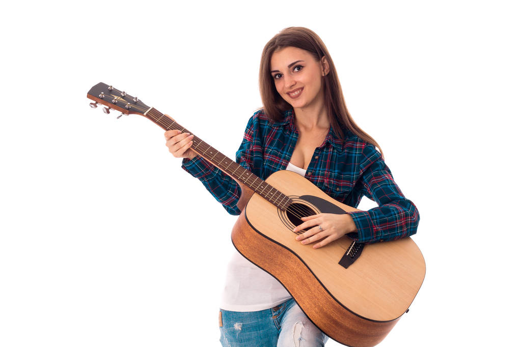 vrouw gitaarspelen en glimlachend op camera - Foto, afbeelding