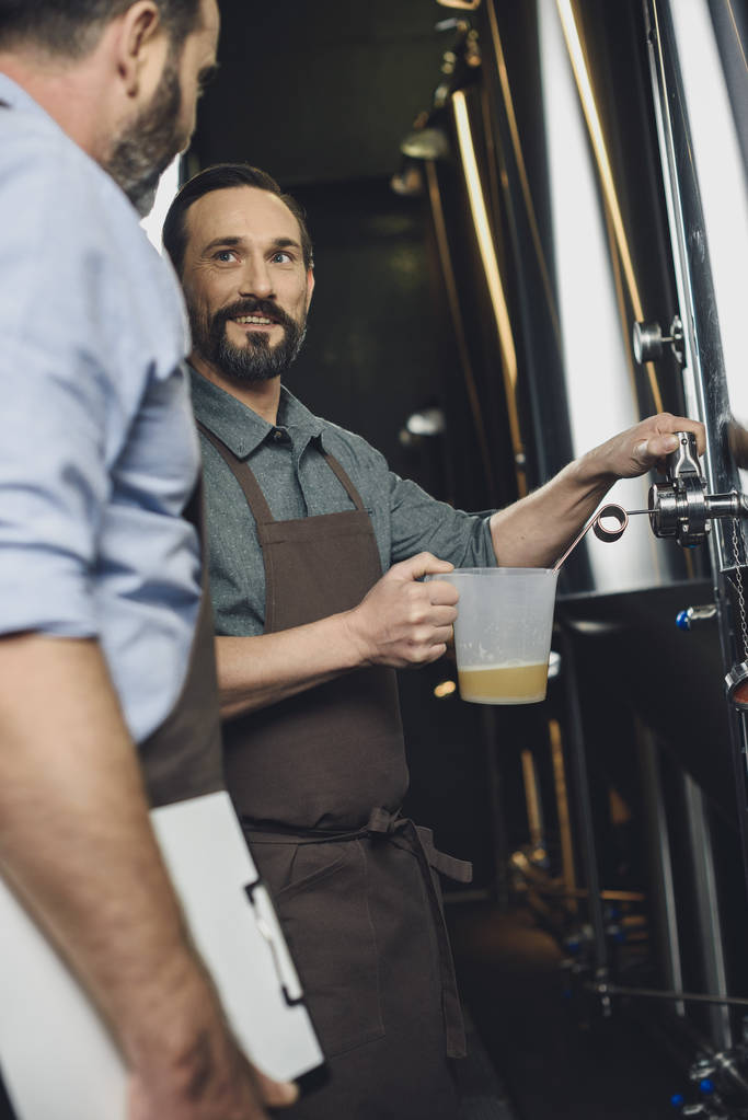 Trabajador cervecero vertiendo cerveza
  - Foto, Imagen