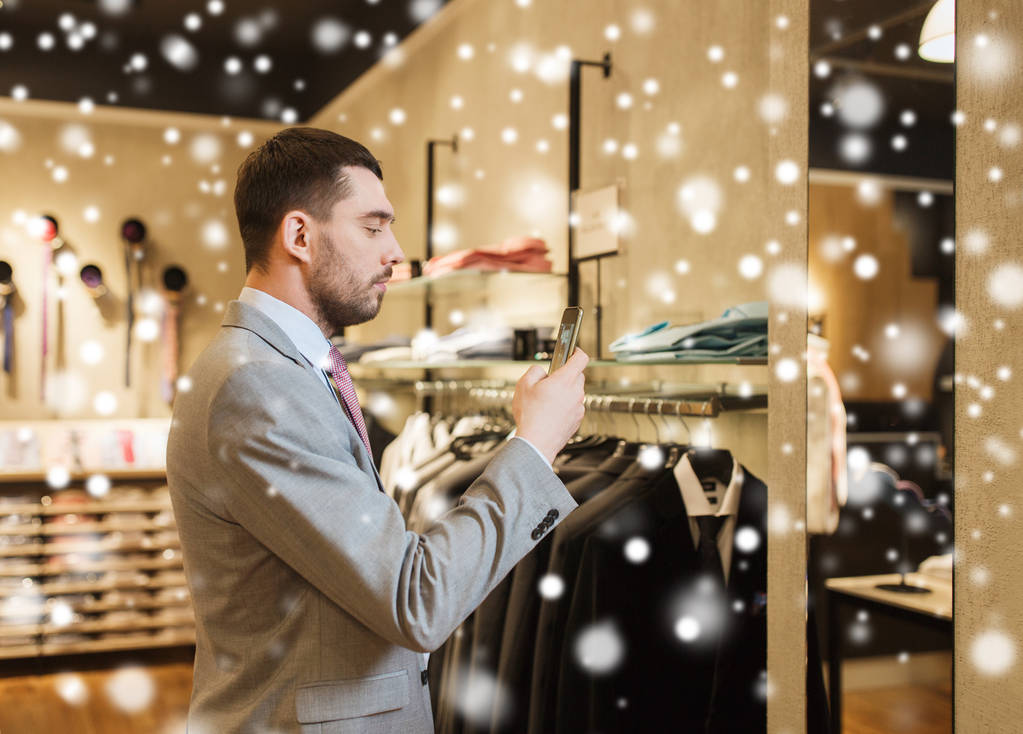 uomo in giacca e cravatta con smartphone al negozio di abbigliamento
 - Foto, immagini