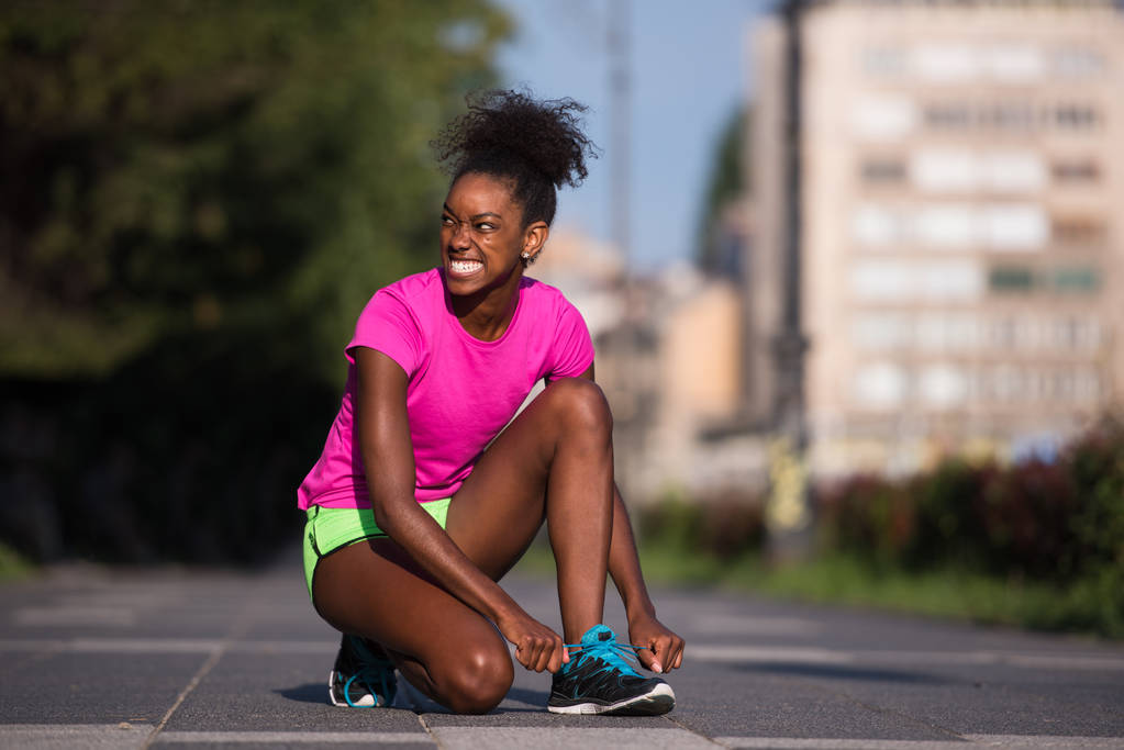 Afrikai-amerikai nő futó cipő csipke szigorítása - Fotó, kép