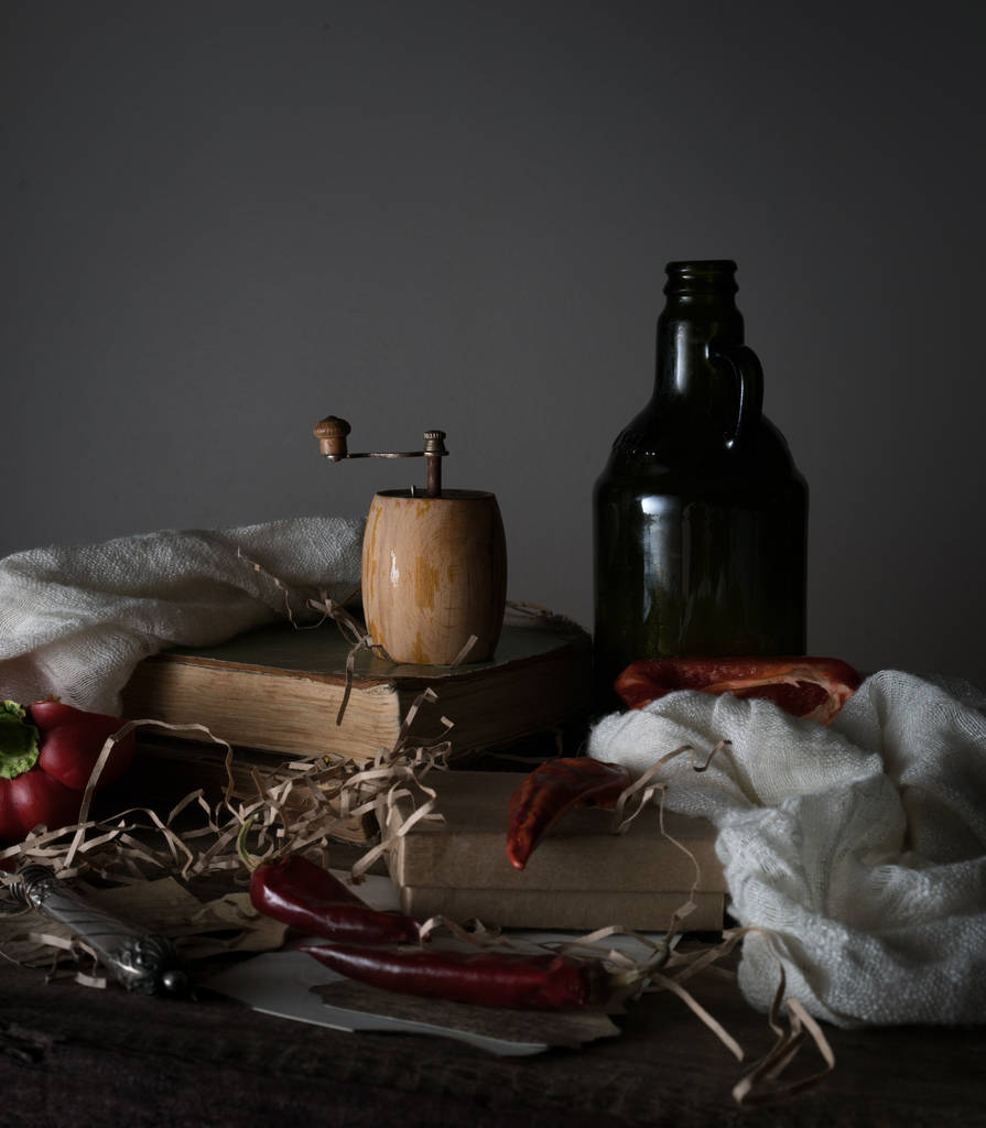 Zátiší, vinobraní. stará láhev s olejem, červenou paprikou, mlýn a ručník na dřevěný stůl. - Fotografie, Obrázek