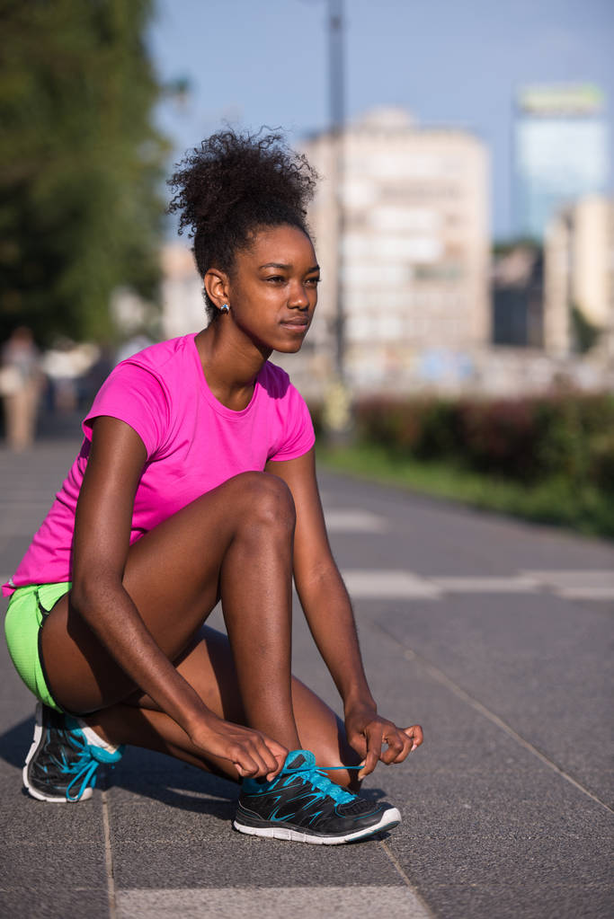 Afrikalı-Amerikalı kadın atlet ayakkabı Dantel sıkma - Fotoğraf, Görsel
