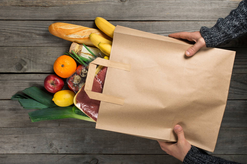 木製キッチンの様々 な健康食品の袋を保持している男 - 写真・画像