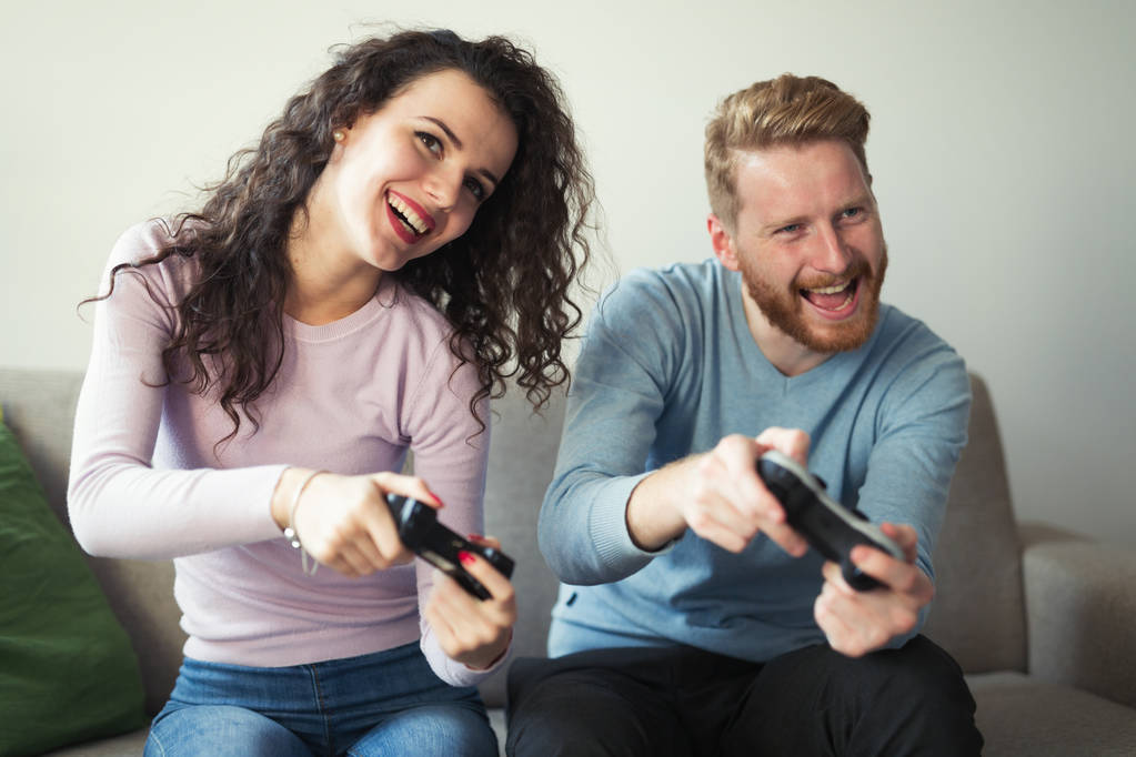 Kaunis pari pelaa videopelejä konsolilla
 - Valokuva, kuva