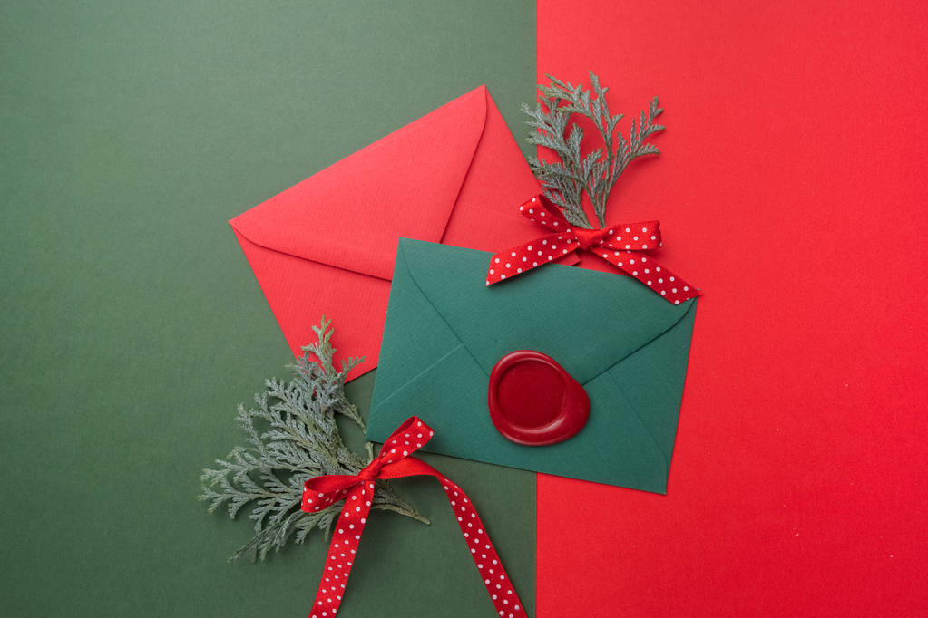 Червоні та зелені конверти на різдвяному фоні. Плоский прошарок
. - Фото, зображення