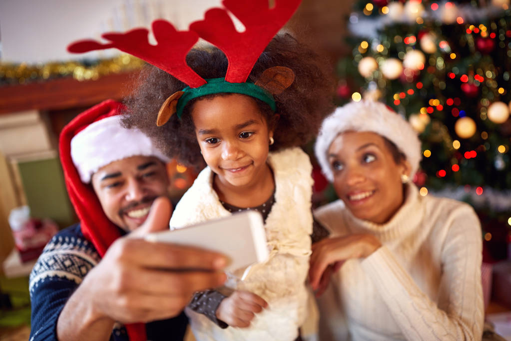 Ευτυχισμένη οικογένεια λαμβάνοντας αυτοπορτρέτα κατά τη διάρκεια των Χριστουγέννων - Φωτογραφία, εικόνα