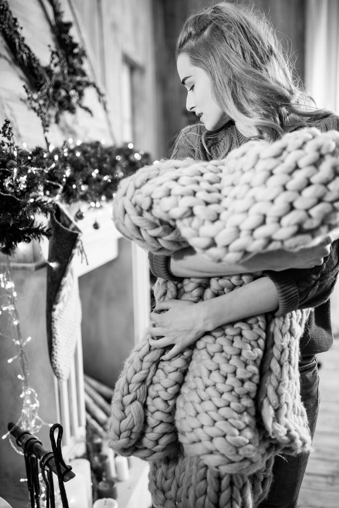 Молодая женщина держит вязаную ткань
 - Фото, изображение