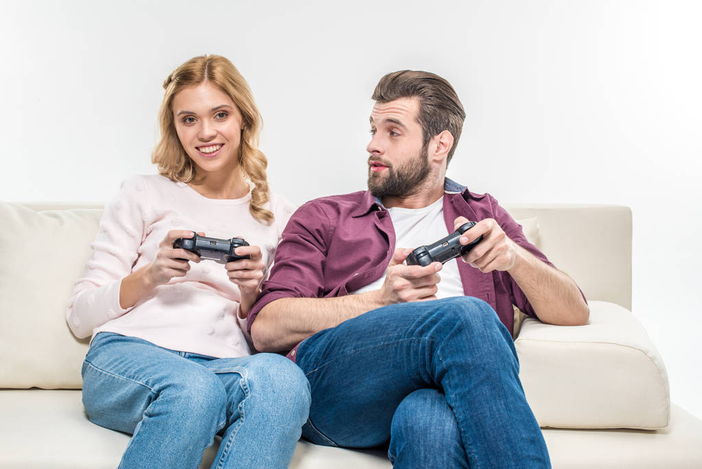 Sonriente pareja jugando con joysticks
   - Foto, imagen