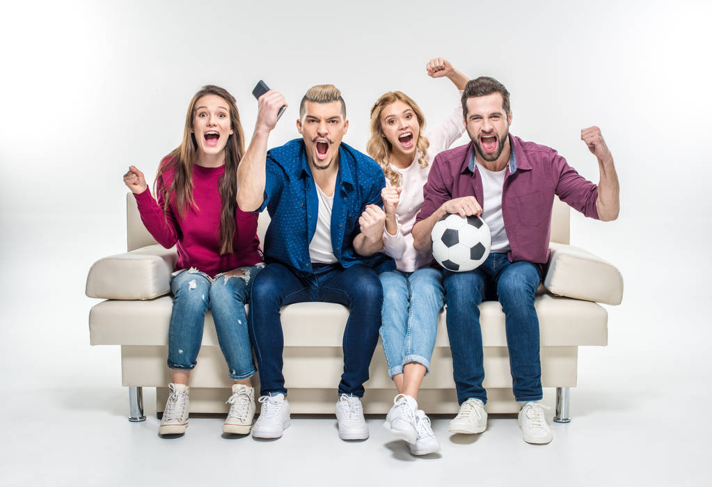Friends sitting on couch with soccer ball   - Photo, Image