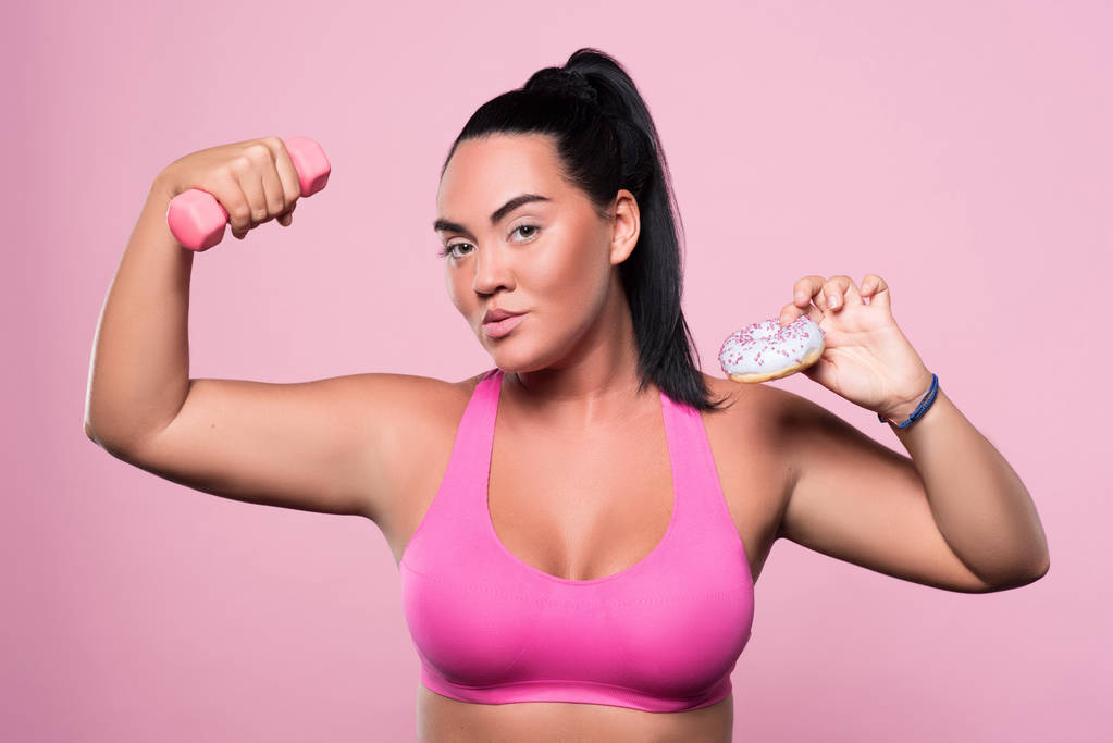 Pleasant plump woman posing on pink background - Photo, Image