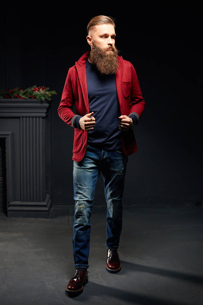 junger Modelmann mit langem Bart steht im dunklen Atelier - Foto, Bild