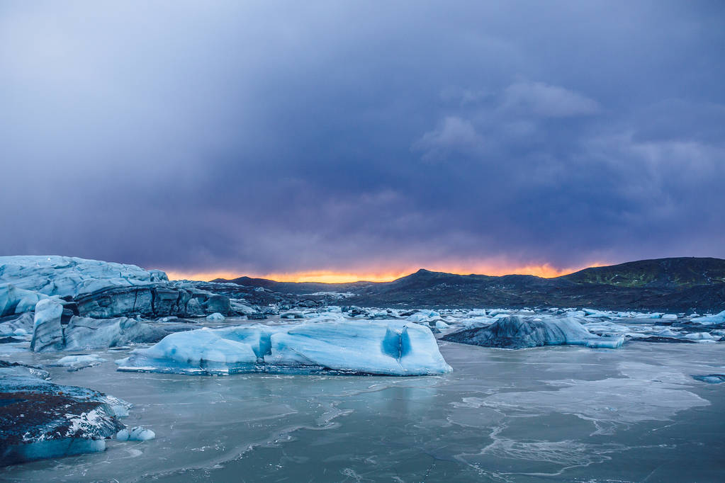 Auringonlasku vuorten yli Islannissa
 - Valokuva, kuva