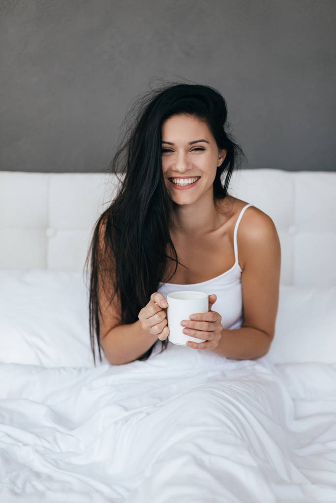 Woman smiling and holding cup - Photo, Image