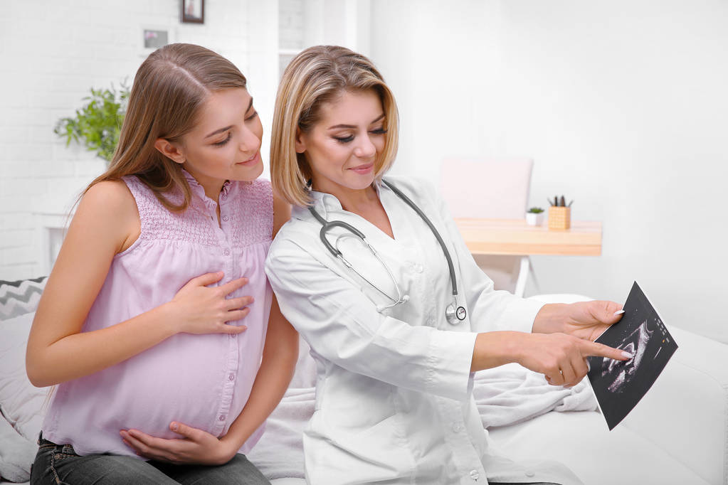 Consulenza ginecologica. Medico mostrando donna incinta ultrasuoni foto
 - Foto, immagini
