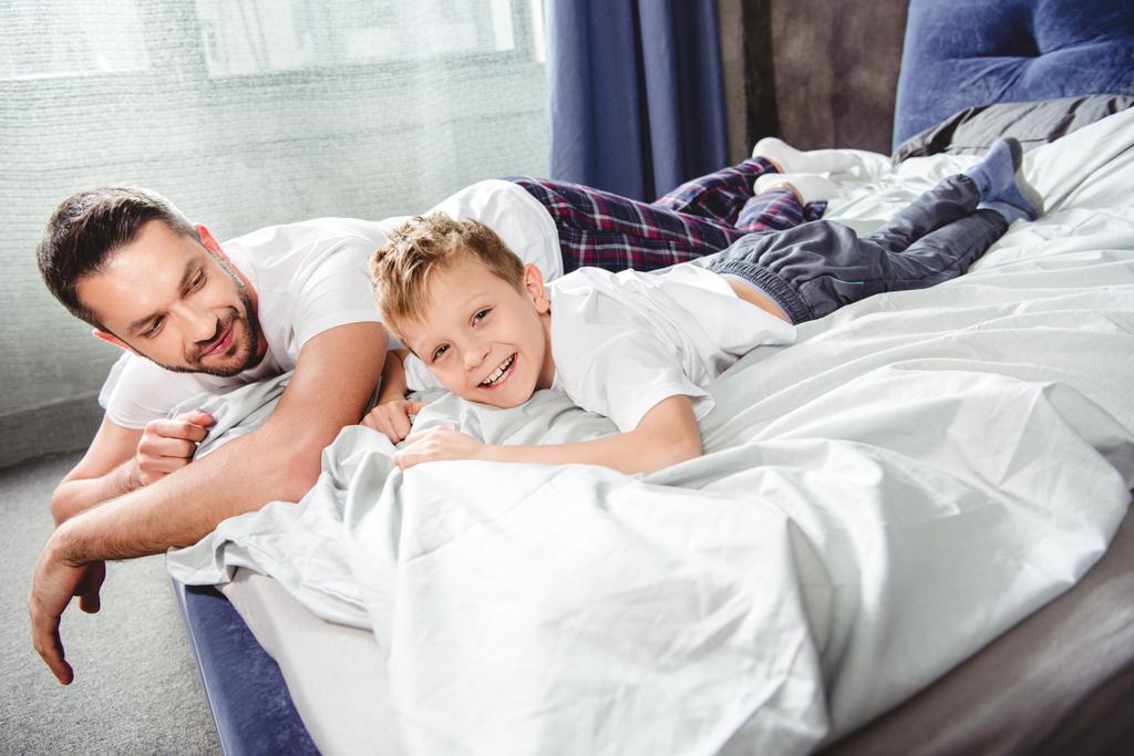 Счастливые отец и сын в постели
   - Фото, изображение