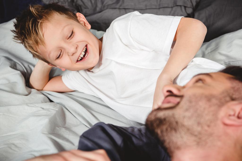 Ευτυχής πατέρας και γιος στο κρεβάτι   - Φωτογραφία, εικόνα