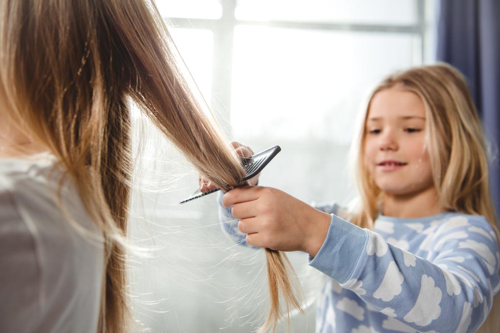 Дочь расчесывает волосы матери
 - Фото, изображение