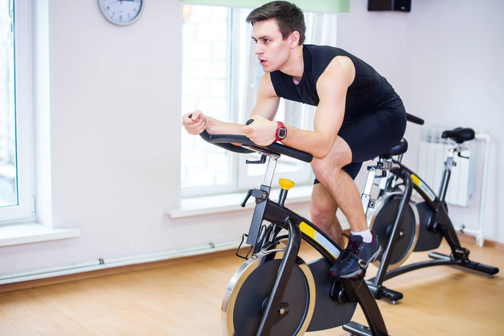 Lekkoatletka mężczyzna rowerowych w siłowni - Zdjęcie, obraz