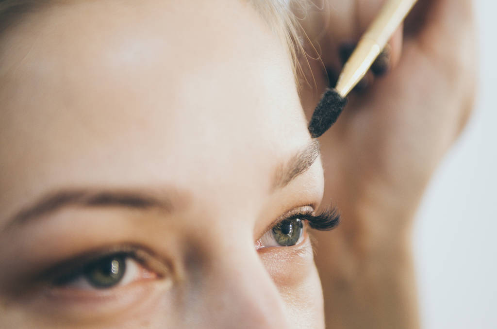 Beautiful young woman doing eyebrow correction - Photo, Image