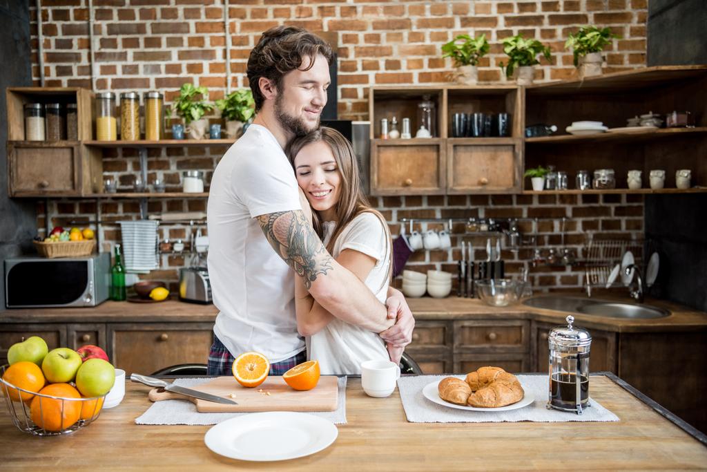 Paar umarmt sich in Küche  - Foto, Bild