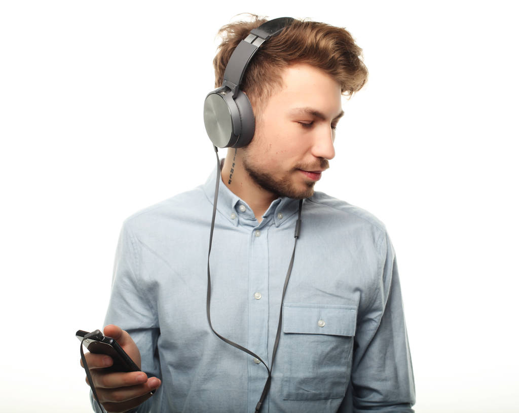 Όμορφος νέος που φοράει ακουστικά και ακούει μουσική.. - Φωτογραφία, εικόνα