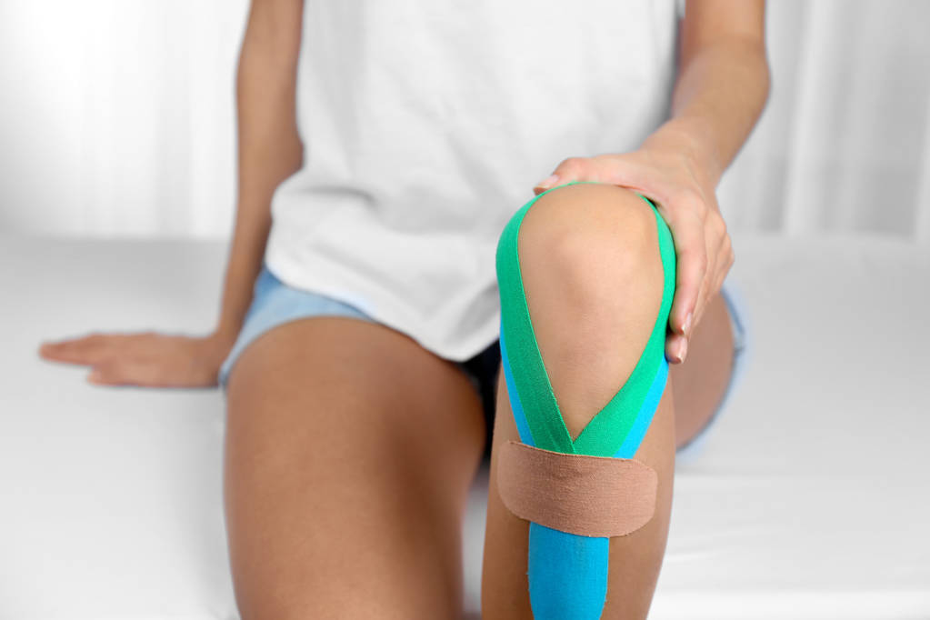 Female knee with physio tape - Photo, Image