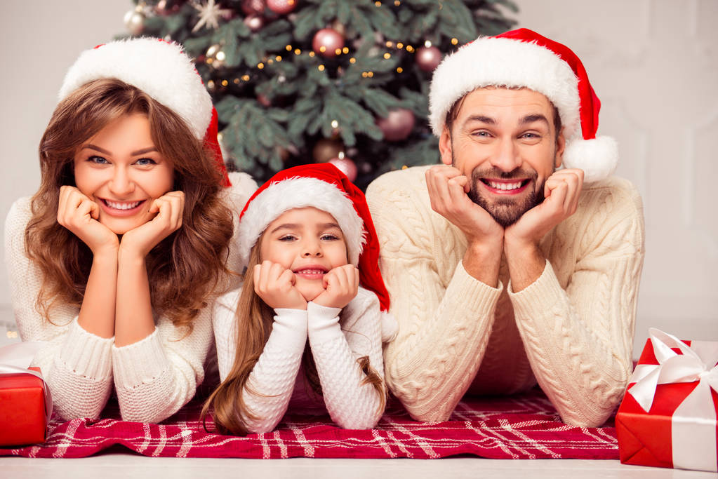 Porträt einer fröhlichen, süßen, glücklichen Familie, die am Weihnachtsbaum liegt - Foto, Bild